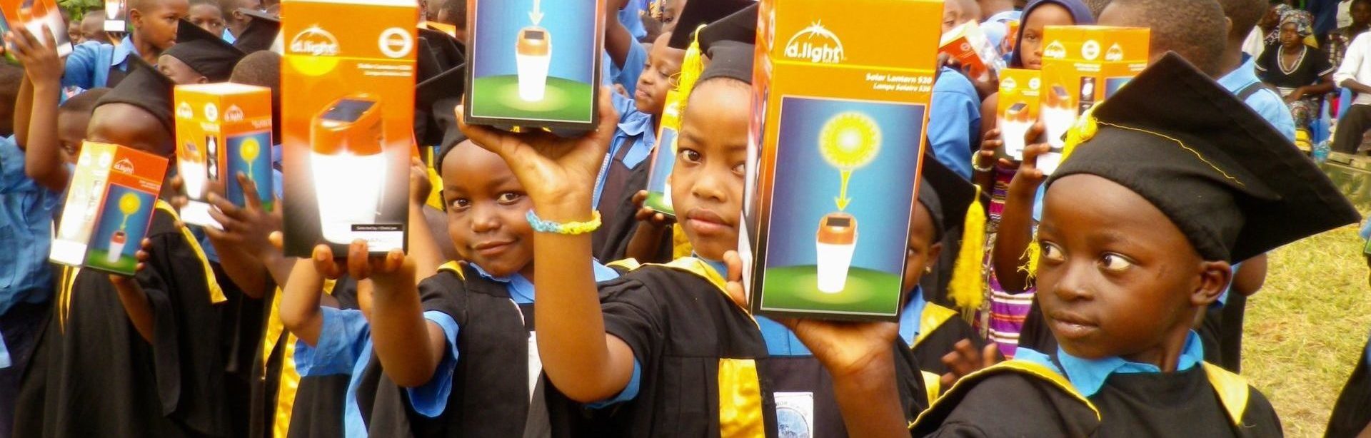 Uphill junior school kindergarten graduates holding solar lanterns on the home page of the uphill trust charity