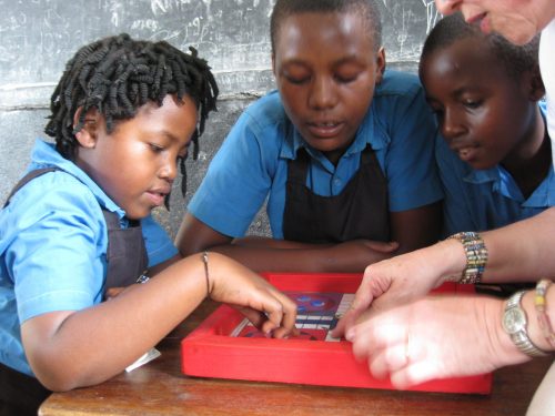 teaching children to play ludo in Uganda