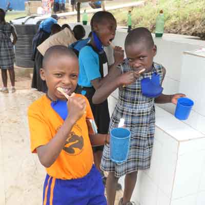 Ugandan school children brushing their teeth at Uphill Junior School
