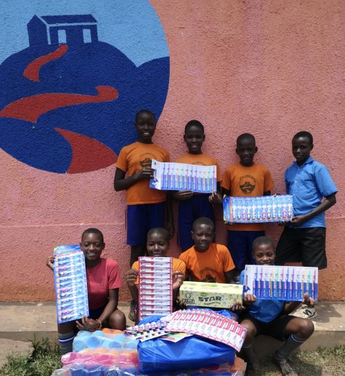 ugandan school pupils showing off a donation of toothbrushes and soap